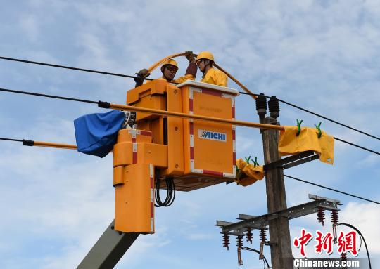 图为国网重庆永川供电公司工作人员在高空带电作业保电。　周毅 摄