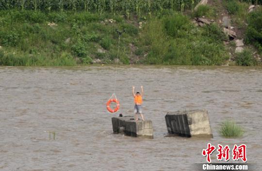 无人机向被困者投送救生圈。　钟欣 摄